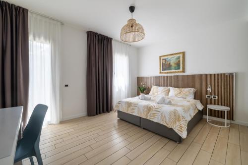 a bedroom with a bed and a table and a chair at Hotel La Pergola di Venezia in Venice-Lido