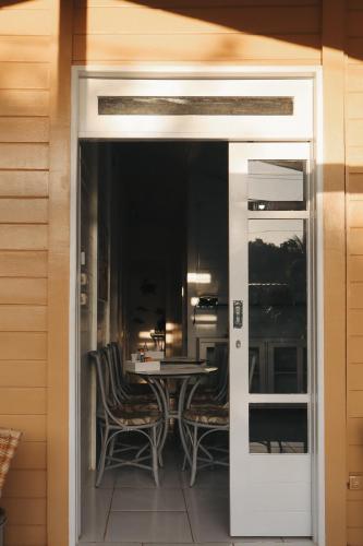 a door leading to a patio with a table and chairs at Pousada do Bita in Fernando de Noronha