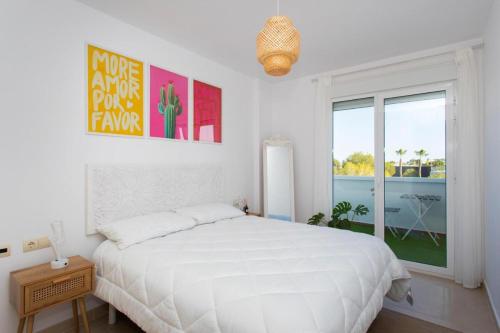 ein weißes Schlafzimmer mit einem großen Bett und einem Fenster in der Unterkunft Wolfie Home Villacosta in Orihuela