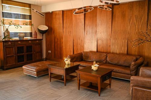 バニャ・ルカにあるHotel Jelenaのリビングルーム(茶色の革張りのソファ、テーブル付)