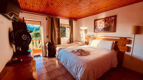 a bedroom with a large bed and a window at Pousada Pinhalense in Santo Antônio do Pinhal