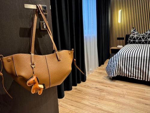 a brown purse hanging on a wall in a bedroom at Vila GARUFA Wellness & Spa in Vysoké Tatry