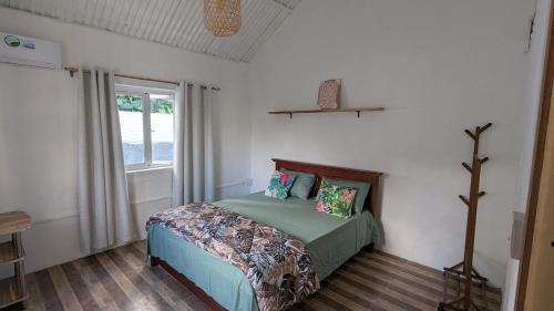 a bedroom with a bed and a window at Kaz Kreol in Trou d'Eau Douce