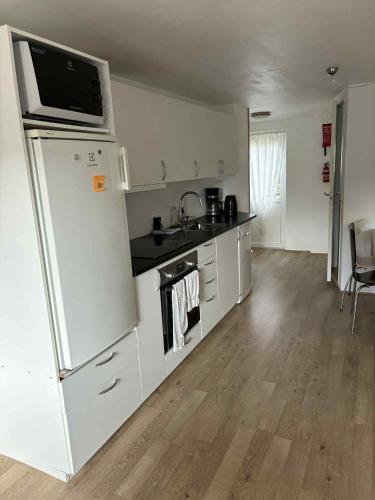 a kitchen with a white refrigerator and a sink at Midbrekkan apartment in Tvøroyri