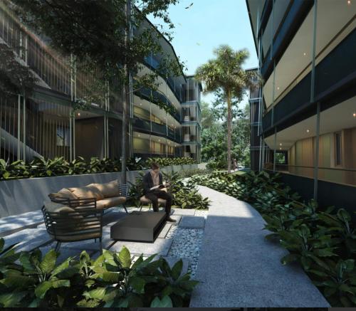 a person sitting on a bench in front of a building at Wings apartman Kittima in Amphoe Koh Samui