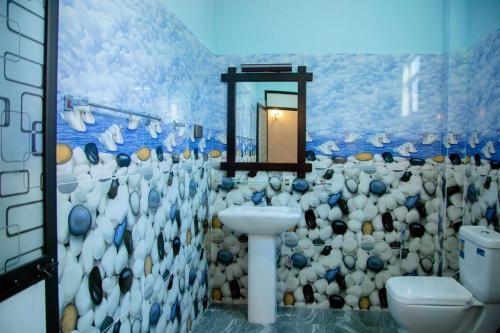 Un baño con inodoro, lavabo y espejo. en My Safari Resort, en Tissamaharama