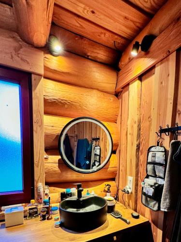 a bathroom with a sink in a log cabin at Feel Timber House in Moux-en-Morvan