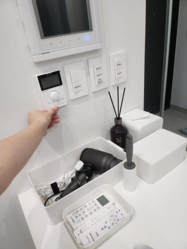 a person holding up a digital camera in a room at SunU Seoul Stay - All Rooms 45m Panoramic Han River View - 4m Ceiling in Seoul
