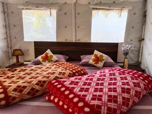 a bedroom with two beds and two windows at H .R. MOUNT VIEW HOMESTAY. in Nainital