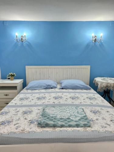 a blue bedroom with a bed and two tables at Art House Old Town in Podgorica