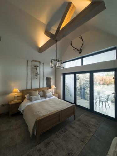 a bedroom with a large bed and a large window at Pink Cottage in Newton Stewart
