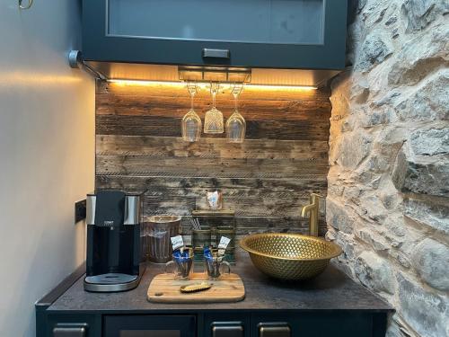 a kitchen with a counter with a sink and a coffee maker at Pink Cottage in Newton Stewart