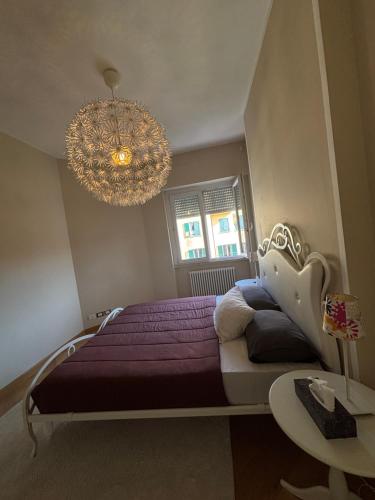 a bedroom with a purple bed and a chandelier at The Green Nest Perugia in Perugia