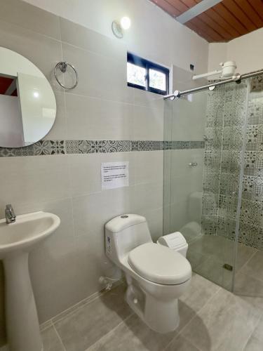 a bathroom with a toilet and a sink and a shower at Entre Cafetales in Jardin