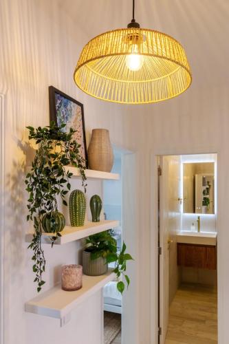 a pendant light hanging over a room with plants on shelves at Casa Phoebe - NEW Renovated Burgau Apartment Sleeps 5 - Beach 1 min in Burgau