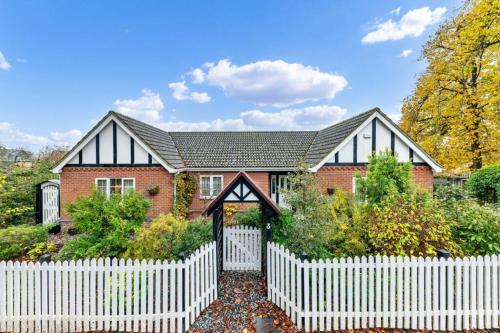a red brick house with a white picket fence at Sizeable 4 bed property on Huntingdon Ring road in Huntingdon
