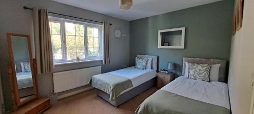 ハンティンドンにあるSizeable 4 bed property on Huntingdon Ring roadのベッド2台と窓のある寝室