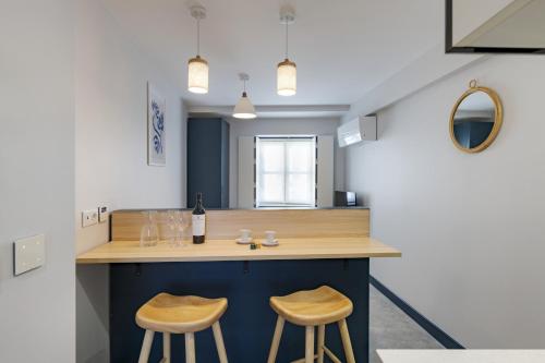 een keuken met een aanrecht met 2 krukken bij Ponto Alto Hotel in Lissabon