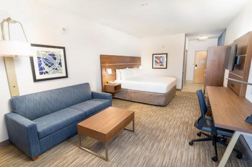 ラスベガスにあるHoliday Inn Express & Suites Las Vegas SW Springvalley by IHGのベッドとソファのあるホテルの部屋