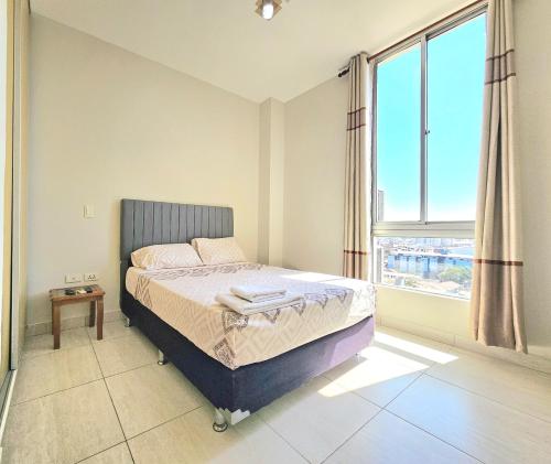 a bedroom with a bed and a large window at En el corazón de Santa Cruz, Departamento de un dormitorio in Santa Cruz de la Sierra