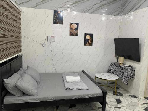 a room with a bed and a tv and a table at CASA Sapphira Transient House in Santo Tomas