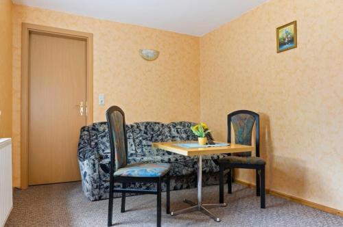 a room with a couch and a table and chairs at Ferienhof Meisdorf - Brückenwohnung in Meisdorf