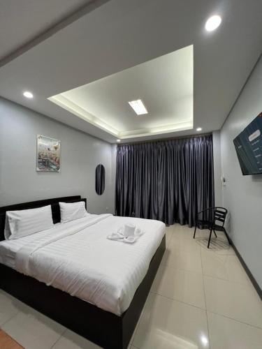 a bedroom with a large bed and a window at PMS Guest House Patong in Patong Beach