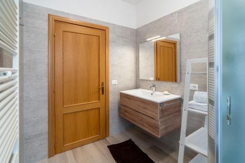 a bathroom with a sink and a wooden door at Podere Limeria Country Home nelle Marche in Fermignano