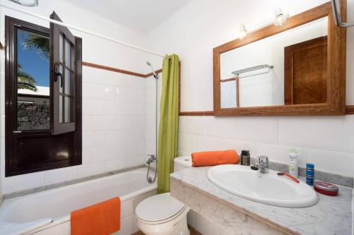 Un baño con lavabo, inodoro y bañera. en Villa Flamingo by Villa Plus, en Playa Blanca