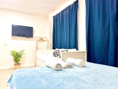 Schlafzimmer mit blauen Vorhängen und einem Bett mit Handtüchern in der Unterkunft COSTA by Hawkins BajoA in Algeciras