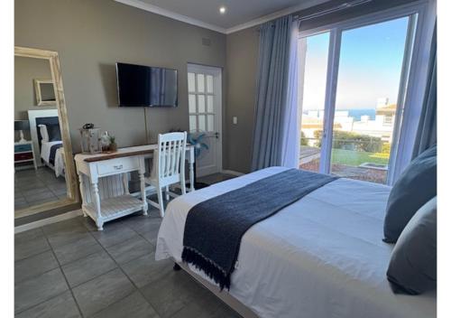 a bedroom with a bed and a desk with a window at Pinnacle Golf Villa 24-3 in DʼAlmeida