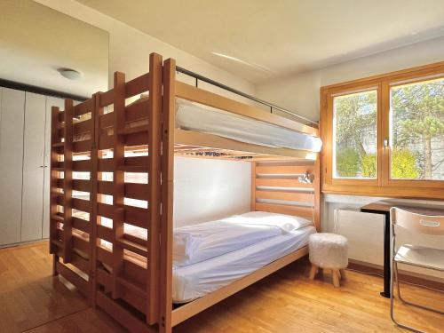 a bedroom with bunk beds and a desk at Chesa Foulla Rosa - 6 pax in Celerina