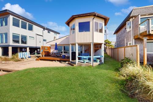 a house with a deck and a house with a yard at 2 Bed 2 Bath Vacation home in Rockaway Beach in Rockaway Beach