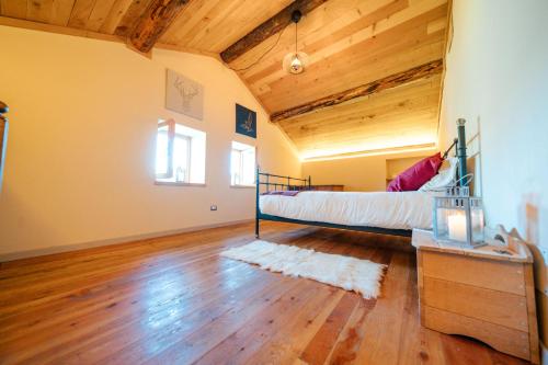 a bedroom with a bed and a wooden ceiling at Baita relax nel bosco in Rasura