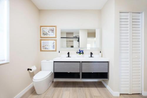 Un baño blanco con lavabo e inodoro. en Pura Vida Villa Miami Luxury Stay Pool & Hot Tub, en North Miami