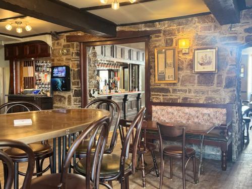 a bar with tables and chairs in a restaurant at The Black Lion Hotel in Cardigan