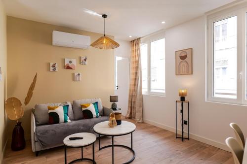 a living room with a couch and a table at Le Chenavard IV-Coeur Lyon-Central air conditioning in La Celle-sous-Gouzon