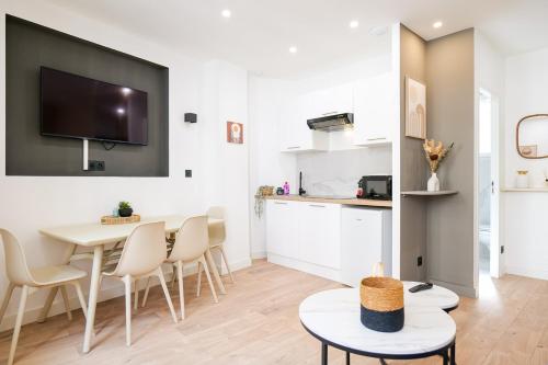 a living room with a table and chairs and a kitchen at Le Chenavard IV-Coeur Lyon-Central air conditioning in La Celle-sous-Gouzon