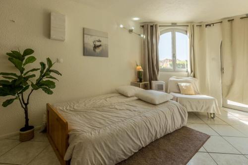 a bedroom with a bed and a potted plant at L'Escapade - Port Murano in Le Barcarès