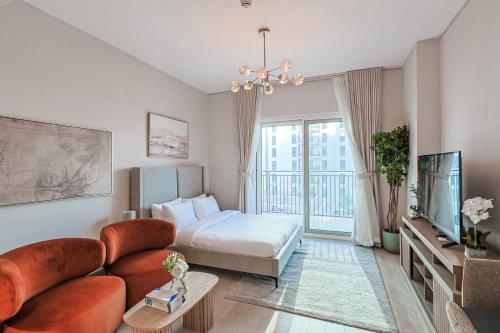 a living room with a couch and a bed and a tv at Seabreeze Studio Yas Island in Abu Dhabi