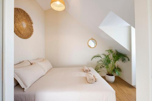 een witte slaapkamer met een bed en een plant bij Ponto Alto Hotel in Lissabon