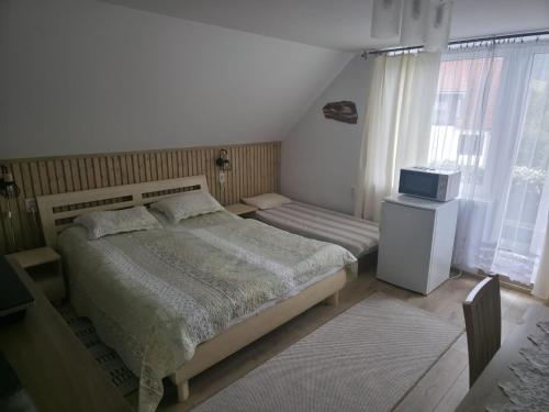 a bedroom with two beds and a television in it at Ubytovanie Otília in Zuberec