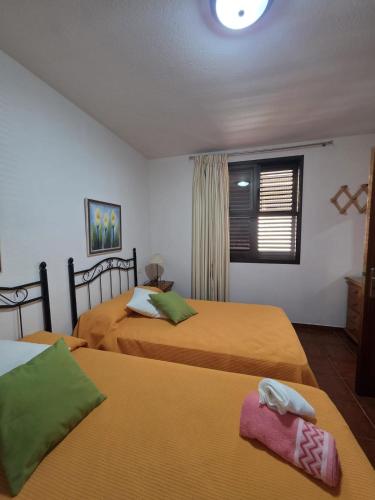 a hotel room with two beds and a window at Miel de Guarapo Apartment in La Gomera