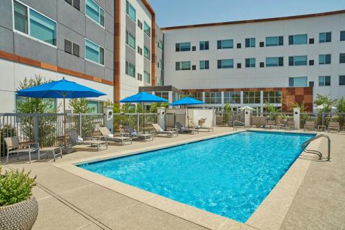 a swimming pool with chairs and umbrellas next to a building at Element Las Vegas Symphony Park in Las Vegas
