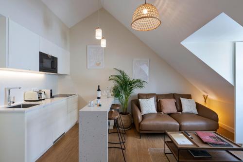 a living room with a couch and a kitchen at Ponto Alto Hotel in Lisbon