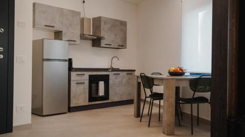 a kitchen with a table and a refrigerator at NAMA STAY Bed and breakfast in Adelfia