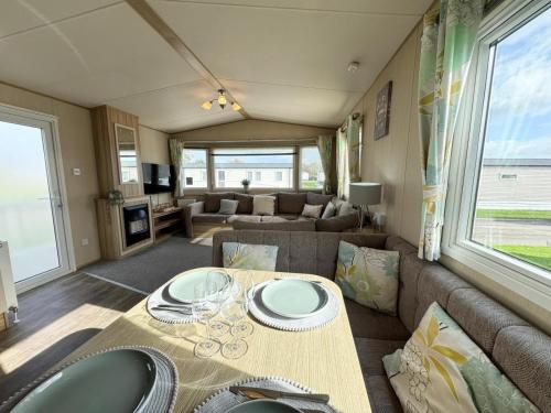 ein Wohnzimmer mit Tisch und Couch in der Unterkunft Park Dean Resorts Premium plot with Mountain view & Decking in Abergele