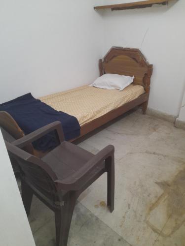 ボーパールにあるComfi Stay Hotel Bhopalの小さなベッドと椅子が備わります。