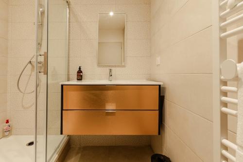 a bathroom with a sink and a mirror and a shower at Le Derby in Valence