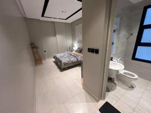 a bedroom with a bed and a bathroom with a sink at Quiet and comfortable apartment near Rakka Sea in Dammam